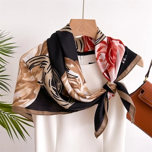 Elegant red rose floral silk scarf with geometric patterns draped on a white dress