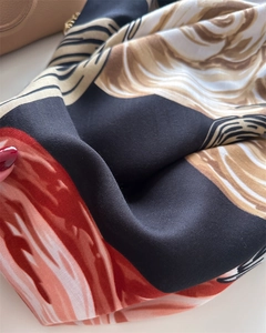 Macro shot showing smooth silk-like texture and abstract floral print on a twill scarf
