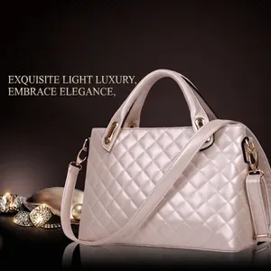 Elegant beige quilted handbag with gold hardware and shoulder strap on a luxury display