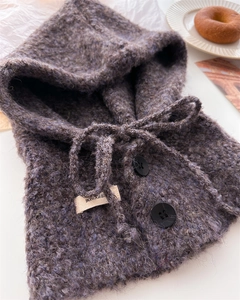 Dettaglio del passamontagna in maglia bouclé grigio-viola con coulisse e bottoni neri