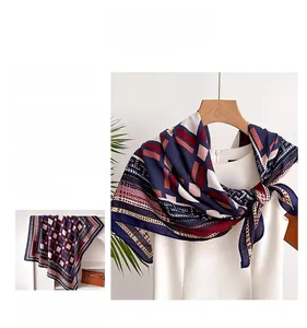 Macro view of geometric plaid silk scarf showing smooth texture and navy burgundy patterns