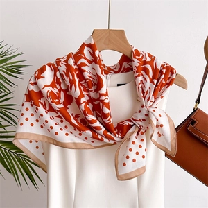 Polka dot camellia silk scarf for women styled with a white dress on a wooden hanger