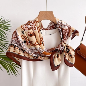 Silk-feel paisley square scarf with earth tones tied on a white outfit for women