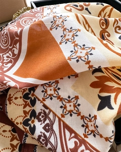 Detailed view of paisley silk scarf texture with classic earth-tone print pattern