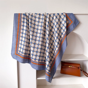 Dettaglio di un foulard in seta di lusso con motivo a catena su espositore bianco