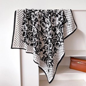 Detailed macro view of polka dot and camellia silk scarf on a white display stand