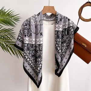 Close-up of a baroque pattern silk scarf draped over a dress in a lifestyle setting