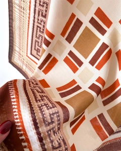 Detail of silk-like scarf showing smooth satin texture and Greek meander patterns