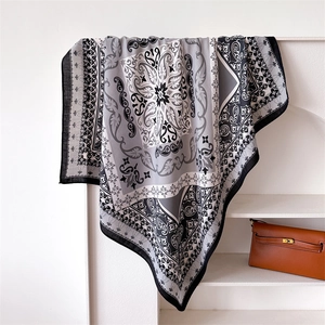 Macro detail of silk scarf featuring vintage paisley and baroque floral patterns on a shelf