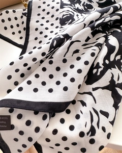 Macro detail of polka dot and camellia pattern silk-feel scarf showing soft texture