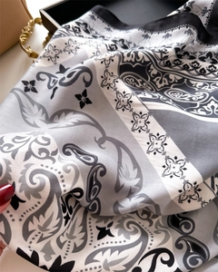 Detailed macro view of paisley pattern and twill weave texture on silk-feel scarf
