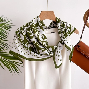 Polka dot camellia silk scarf in green and white styled on a white summer dress