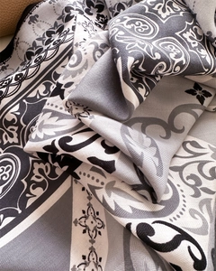 Detailed macro view of herringbone texture and baroque floral print on silk scarf