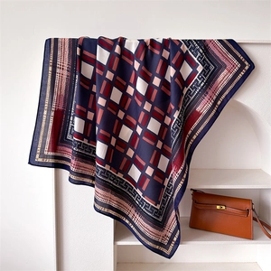 Navy and red geometric print silk-like square scarf draped in a minimalist niche