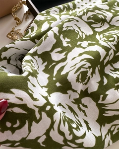 Detailed view of green camellia polka dot silk scarf with elegant herringbone texture