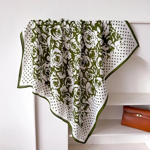 Detail showing green floral camellia and polka dot print on silk scarf with fine stitching
