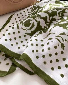 Detailed macro view of olive green floral silk scarf with fine twill texture and dots