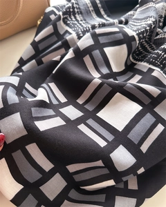 Close-up of twill silk scarf with vintage plaid and houndstooth pattern in monochrome