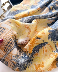 Close-up of vintage silk scarf featuring tropical palm leaves and European architecture
