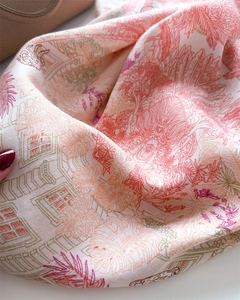 Close-up of printed silk scarf with tropical leaf patterns and smooth texture