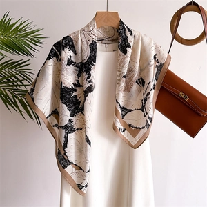 Silk scarf with squirrel floral print and contrasting hem on a white dress display