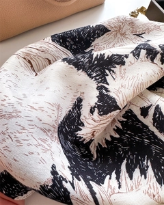 Detailed view of luxury silk scarf with black and white abstract print and fine rolled edge