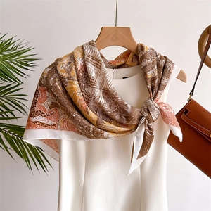 Silk-textured square scarf with tropical jungle landscape print styled on a dress