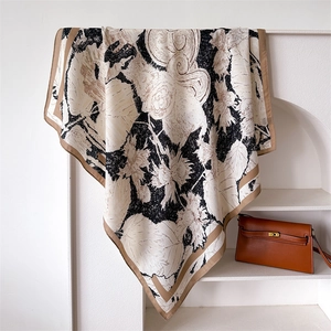 Detail of silk-like floral square scarf draped on stand with retro botanical patterns