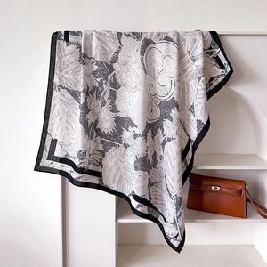 Macro view of silk scarf with floral squirrel print and bold black border detail