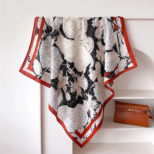 Artistic square silk scarf featuring abstract floral prints and a bold red border detail