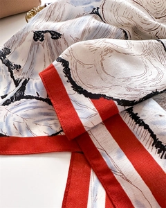 Close-up of silk scarf with vintage leaf print and red borders showing twill texture