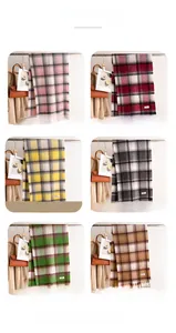 Dettaglio di sciarpe a quadri con nappe in sei colori e morbida trama in cashmere