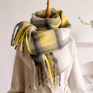 Sciarpa a quadri gialla e grigia con lunghe frange indossata su un cappotto beige