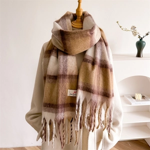 Sciarpa a quadri sfumati marroni oversize con lunghe nappe su un cappotto beige