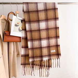 Dettaglio di morbida sciarpa a quadri effetto cashmere con spesse frange su stand