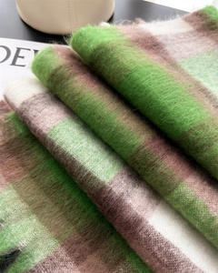 Dettaglio di una spessa sciarpa a quadri in mohair verde bosco e marrone caffè