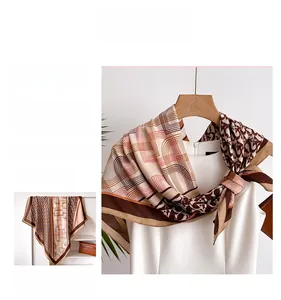 Detail of silk-like scarf featuring geometric monogram print in brown and caramel tones