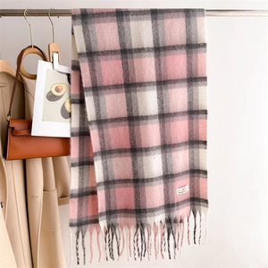 Dettaglio di sciarpa a quadri rosa e grigi con frange lunghe e morbida trama in cashmere
