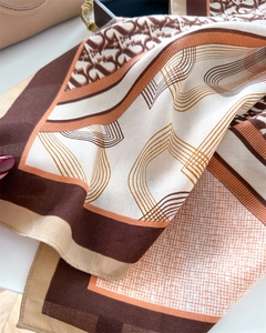 Detailed macro view of 90cm silk-like scarf featuring letter prints and herringbone texture