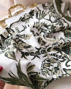 Nahaufnahme von Vintage-Seidenschal mit grünem Blumendruck und gestreiftem Rand