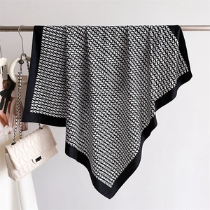 Detail of silk-like scarf with black and white V-pattern and elegant draped texture