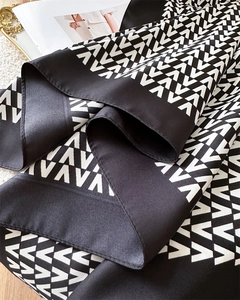 Detail of silk-like scarf with black and white V-pattern and elegant twill texture