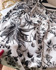Detail von seidenähnlichem Schalstoff mit eleganten Blumendrucken und glatter Textur