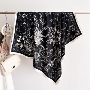 Detail eines Seidenschals mit Vintage-Blumen- und Waldtierdruck auf schwarz-weißem Stoff