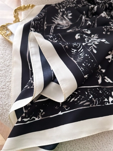 Detailansicht der Seidenschal-Struktur mit floralem Print und elegantem Rand