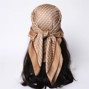 Silk-like square scarf with retro V-letter monogram pattern worn as a headscarf