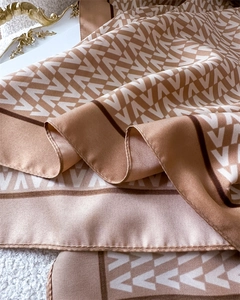 Detail view of champagne silk scarf with V-pattern print and fine machine-rolled edges