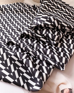 Detailed view of black and white geometric triangle pattern silk scarf with elegant folds