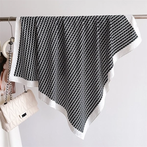 Classic black and white silk-like square scarf with repeated V-logo geometric patterns