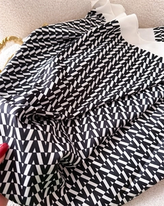 Macro shot of silk scarf detailing geometric V-pattern and subtle twill fabric texture